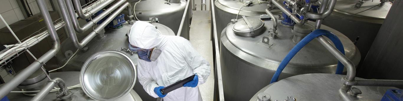 Dairy process worker checking milk quality in a factory